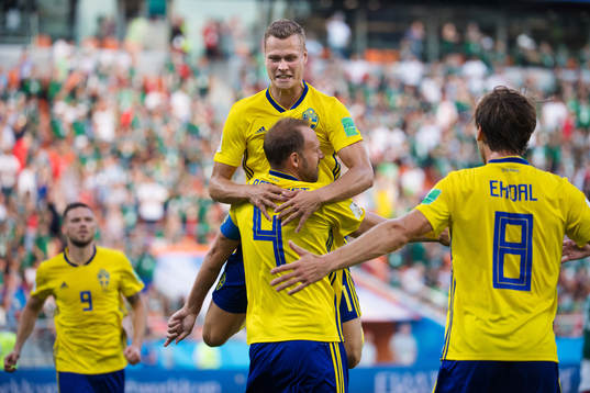 Viktor Claesson jumps onto Andreas Granqvist of Sweden