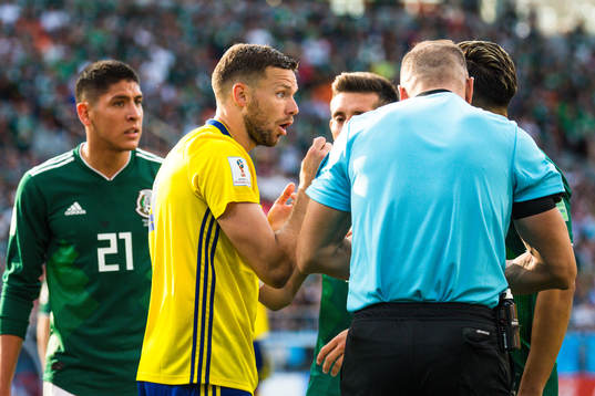 Marcus Berg of Sweden with Referee Nestor Pitana