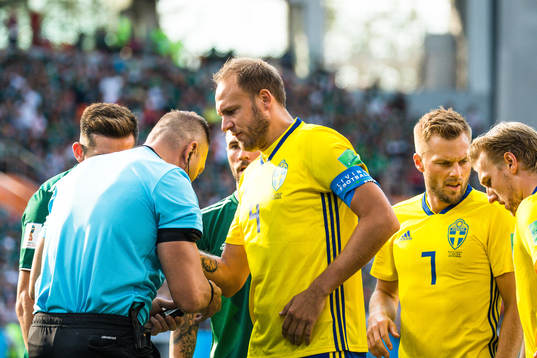 Andreas Granqvist of Sweden with Referee Nestor Pitana