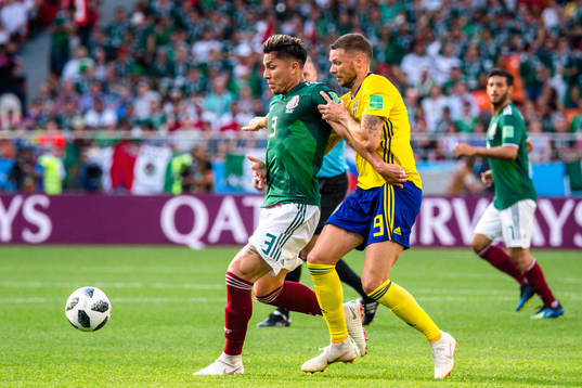 Carlos Salcedo  of Mexico and Marcus Berg of Sweden