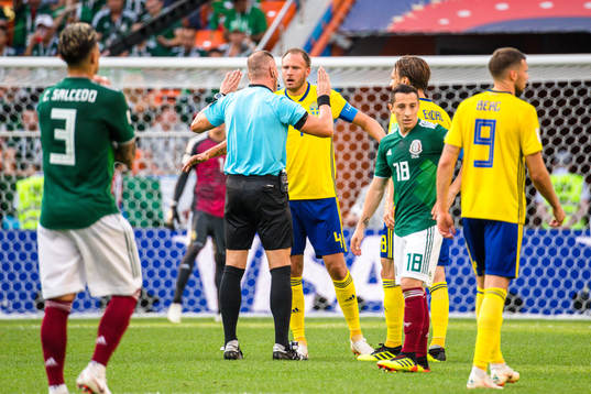 Referee Nestor Pitana and Andreas Granqvist of Sweden