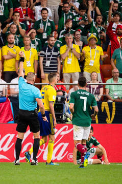 Mikael Lustig of Sweden receives a yellow card