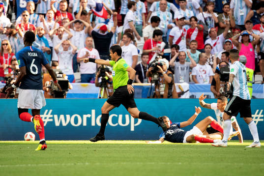 referee Alireza Faghani awards Kylian Mbappe of France a