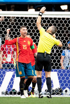 Handball by Gerard Pique of Spain and referee Björn