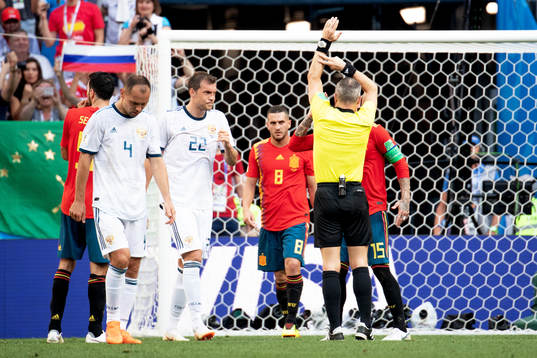 Handball by Gerard Pique of Spain and referee Björn
