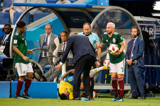 Neymar of Brazil with an injury and Miguel Layun of Mexico
