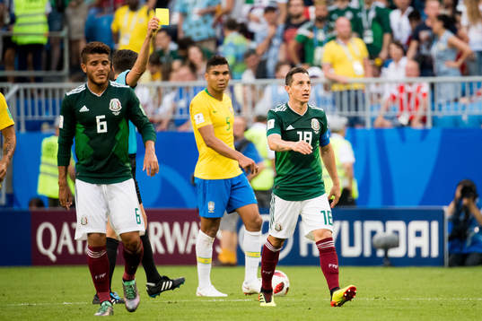 Andres Guardado of Mexico is shown a yellow card