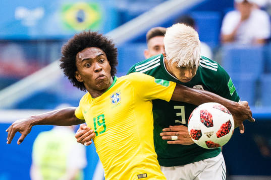 Willian of Brazil in action with Carlos Salcedo of Mexico