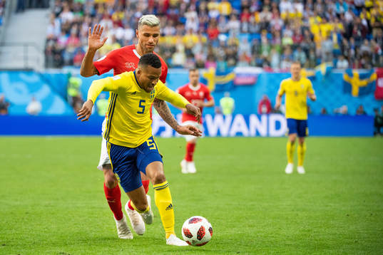 Martin Olsson of Sweden competes for the ball with Valon