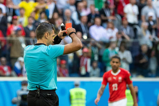 Referee Damir Skomina gives a reda card to Michael Lang of