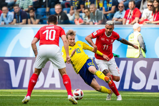 Emil Forsberg of Sweden tackled by Valon Behrami of