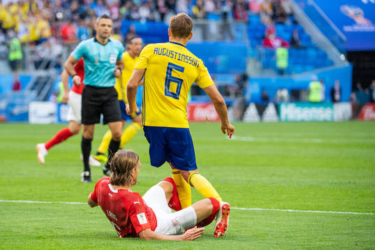 Michael Lang of Switzerland tackles Ludwig Augustinsson of