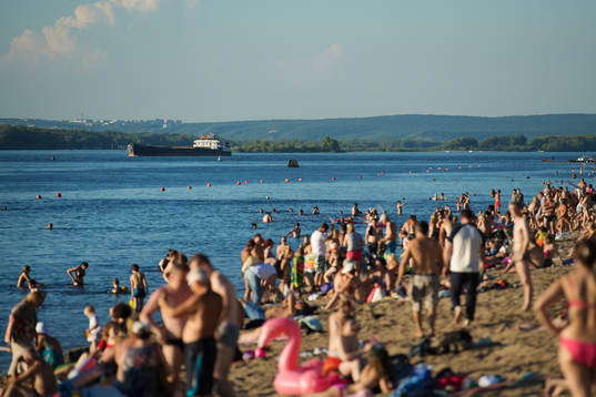 A boat passes by a beach
