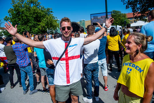 En engelsk supporter bland alla svenska följer matchen