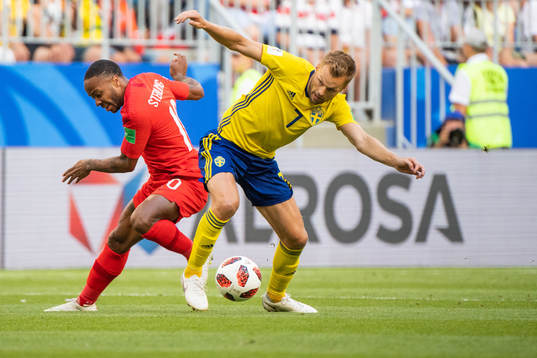 Raheem Sterling of England competes for the ball with