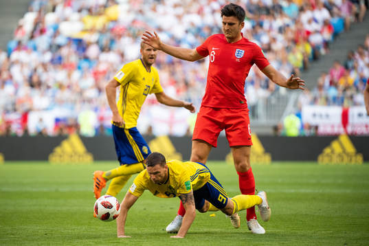 Marcus Berg of Sweden falls in a duel with Harry Maguire of