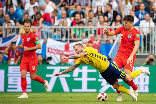 John Guidetti of Sweden falls in a duel with Harry Maguire