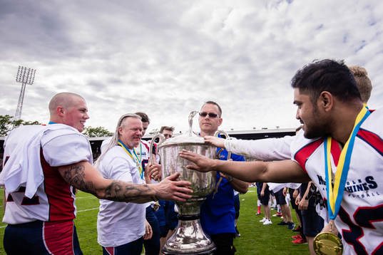 Stockholm Mean Machines spelare jublar med pokalen som