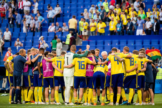 The players of Sweden gather in a ring