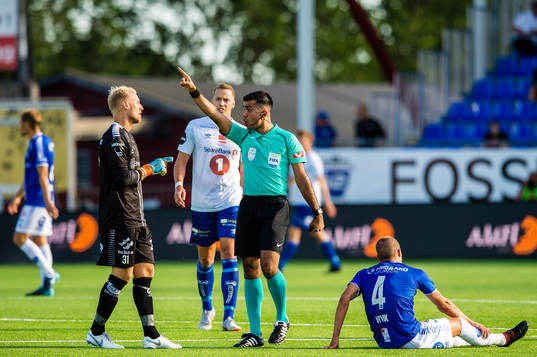 Aslak Falch of Sarpsborg 08 argues with Rohit Saggi, referee