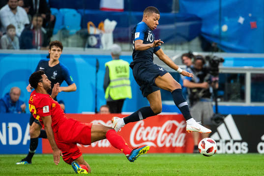 Dedryck Boyata of Belgium tackles Kylian Mbappe of France