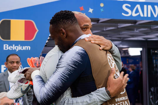 Assisting coach Thierry Henry of Belgium hugs a french