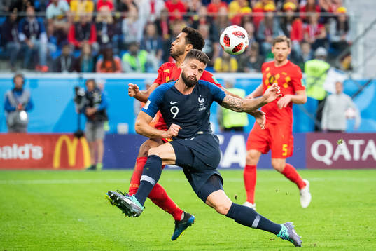 Olivier Giroud of France competes for the ball with Moussa