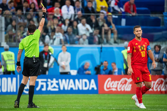 Eden Hazard of Belgium receives a yellow card bby referee