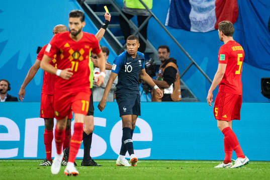 Kylian Mbappe of France receives a yellow card
