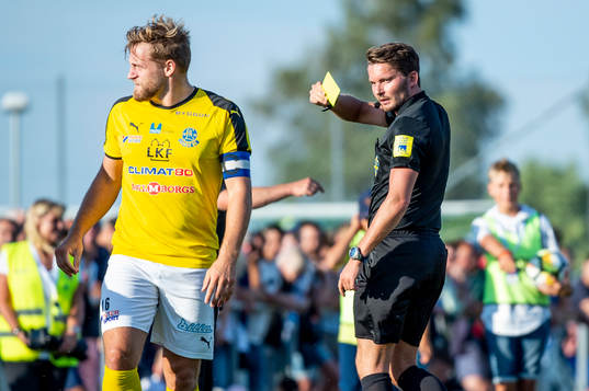 Domaren Joakim Östling ger Lunds Martin Johansson gult kort