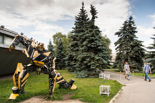 People outside a transformers museum Muzey Vosstaniya Mashin