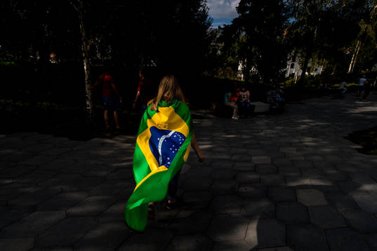 A fan of Brazil are seen walking in a park in central Moscow