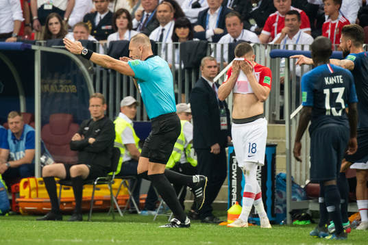 Referee Nestor Pitana calls a penalty