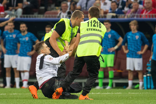 Stewards drag a pitch invader