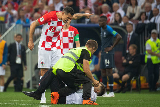 Dejan Lovren of Croatia reacts against a pitch invader who
