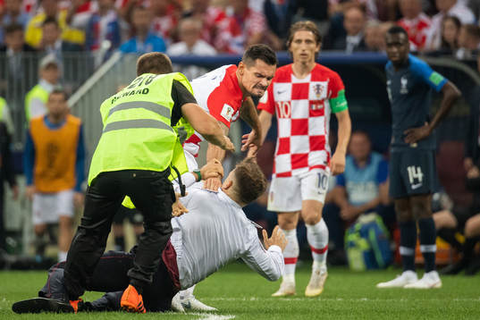 Dejan Lovren of Croatia reacts against a pitch invader