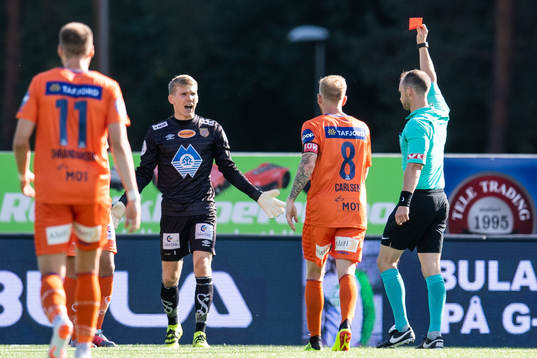 Referee Christian Moen gives a red card to a player of