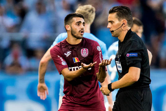 Silva Oliveira of Cluj and referee Andrew Dallas
