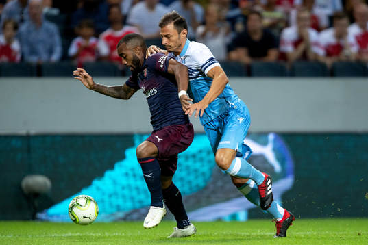 Alexandre Lacazette of Arsenal and Stefan Radu of Lazio