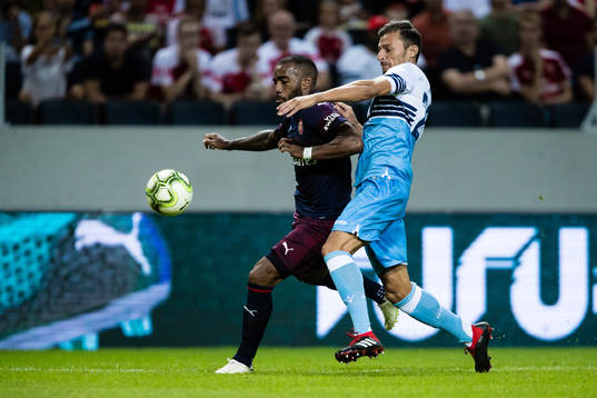 Alexandre Lacazette of Arsenal and Stefan Radu of Lazio