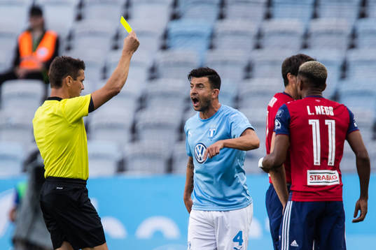 Behrang Safari of Malmö FF gets a yellow card from referee