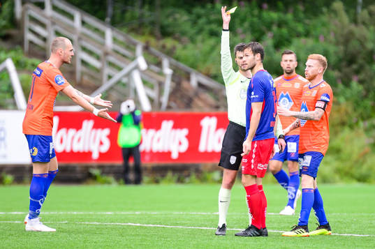 Mathias Dahl Abelsen of Tromsdalen receives a yellow card