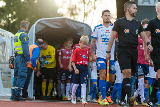 Spelare på väg in på planen före fotbollsmatchen i