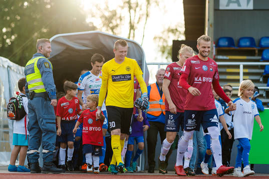 Spelare på väg in på planen före fotbollsmatchen i