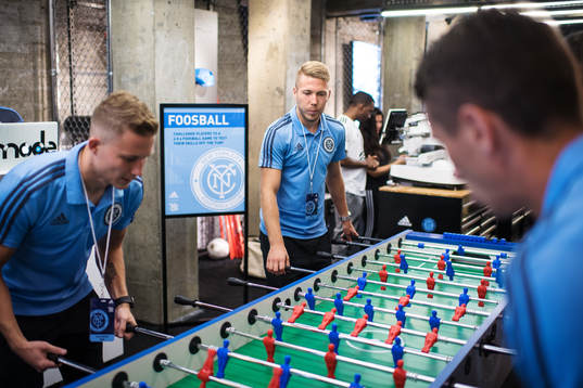 Anton Tinnerholm plays foosball with teammates at a press