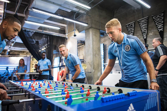 Anton Tinnerholm (R) plays foosball with teammates at a
