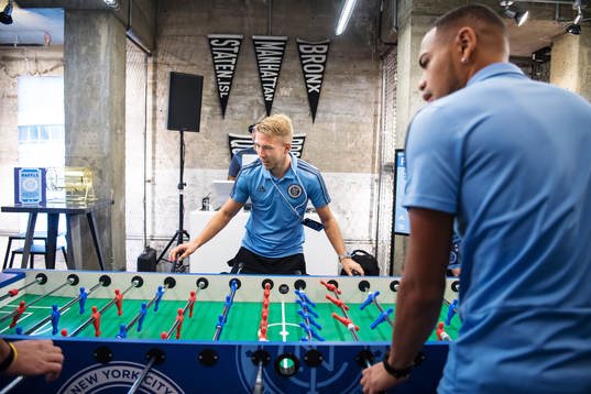 Anton Tinnerholm plays foosball with teammates at a press