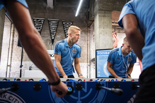 Anton Tinnerholm plays foosball with teammates at a press
