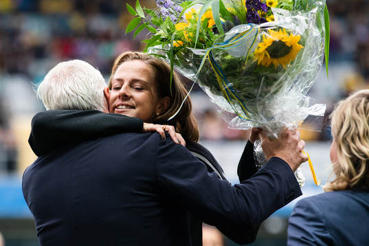 Lotta Schelin (mitten) av generalsekreterare Håkan