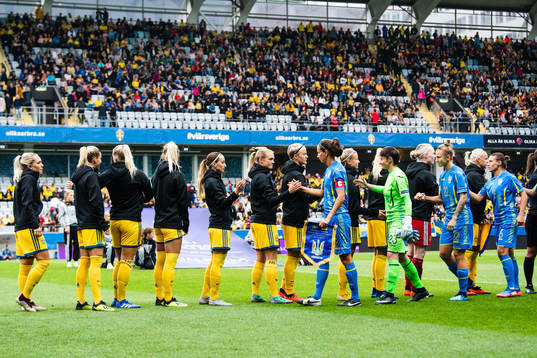Sveriges och Ukrainas spelare hälsar på varandra